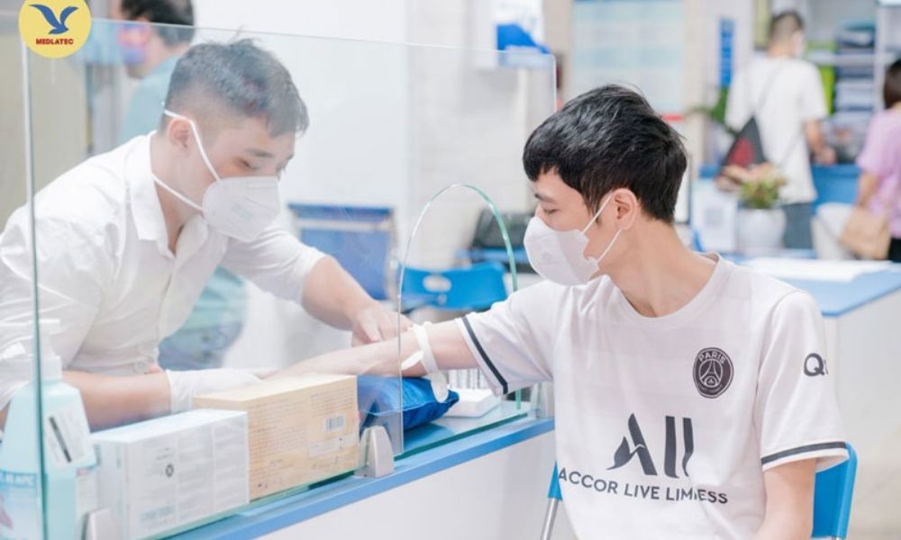 Kỹ thuật viên lấy mẫu xét nghiệm cho khách hàng tại Phòng khám Chuyên khoa Xét nghiệm MEDLATEC Hòa Bình