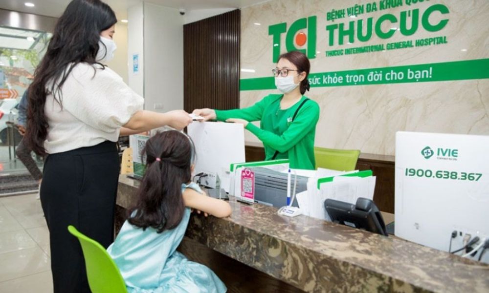Nhân viên y tế hỗ trợ người bệnh làm thủ tục khám tại quầy tiếp nhận